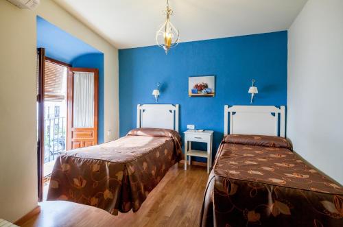 奥苏纳萨尔瓦多布兰科卡瓦略旅舍的蓝色墙壁客房的两张床