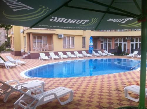 阳光海滩Beatris Family Hotel的一个带躺椅和遮阳伞的游泳池