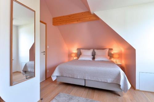 凯泽贝尔Gîte les oiseaux的一间卧室配有一张床和一面大镜子