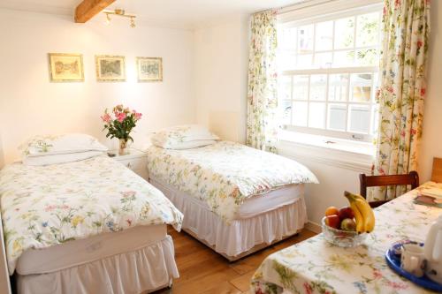 希灵登Swan Guest House LONDON - HEATHROW的带窗户的客房内设有两张单人床。