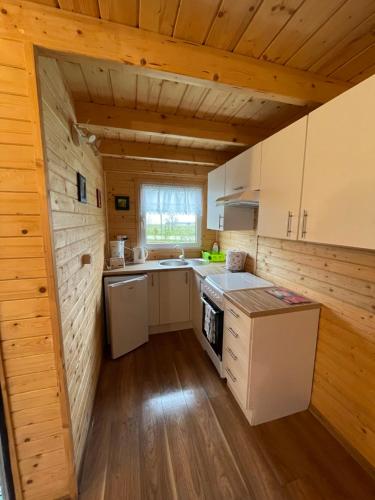 斯维诺乌伊希切Domek letniskowy的厨房设有木墙和木地板