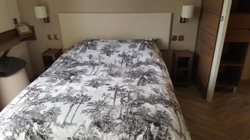 迪纳尔Domaine du bois d amour的一间卧室配有一张带黑白毯子的床