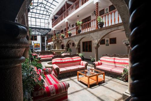 库斯科Munay Wasi Inn的大厅,在大楼里配有沙发和桌子