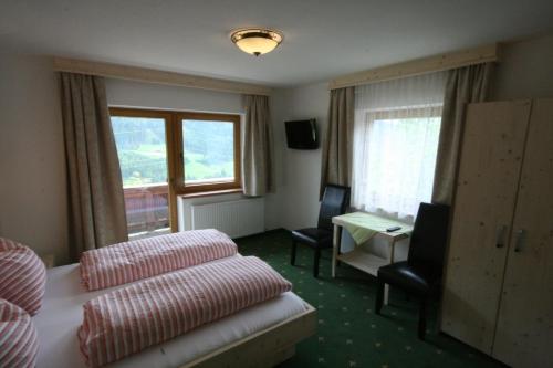 格尔洛斯贝格"Adamerhof"的配有一张床、一张书桌和一扇窗户的酒店客房