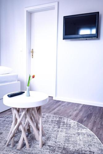 韦斯特兰Flippi-s-Hues-NORD的一间设有白色桌子的房间和墙上的电视