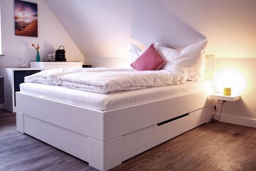 韦斯特兰Flippi-s-Hues-SUeD的白色的床、白色床单和粉红色枕头