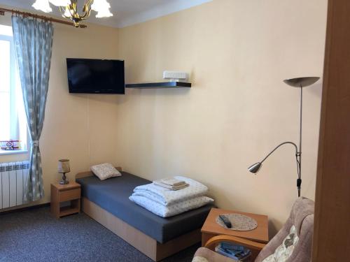 奥尔什丁Mieszkanie na Starym Mieście的小房间设有一张床铺,墙上配有电视