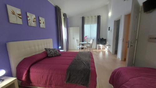 卡拉塔菲米迪塞杰斯塔住宿加早餐旅馆的卧室设有紫色墙壁、一张床和一张桌子
