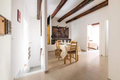 那不勒斯Residenza San Gregorio Armeno的一间拥有白色墙壁和桌椅的用餐室