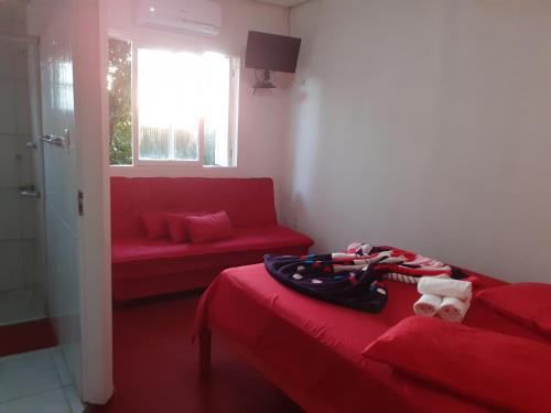 卡内拉Magias da Serra的一间设有红色床和红色沙发的房间