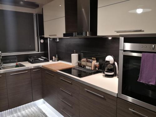 斯巴达Luxury Home的厨房配有棕色橱柜和炉灶烤箱