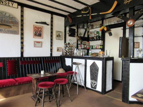 伊尔弗勒科姆Avoncourt Lodge的餐厅的酒吧,有红色凳子