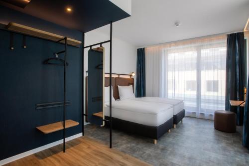 布达佩斯H2 Hotel Budapest的一间卧室设有一张床和一个大窗户