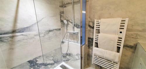 卡马雷Appart'Hôtel du Bout du Monde的玻璃门淋浴和毛巾