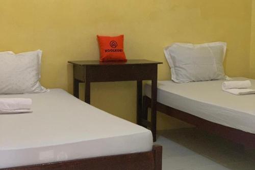 先达KoolKost near Budi Mulia Siantar的一张桌子上方的盒子,房间内设有两张床