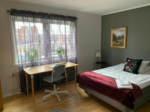 乌普萨拉乌普萨拉公寓酒店的一间卧室配有一张床、一张书桌和一个窗户。