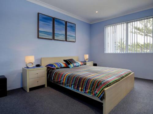 坦卡里Anchorage 7的一间卧室配有一张蓝色墙壁的床和一扇窗户