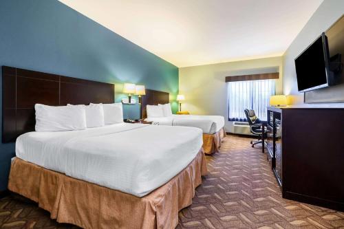 朗维尤La Quinta by Wyndham Longview North的酒店客房配有两张床和一张书桌