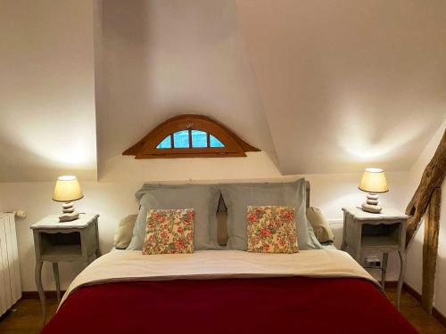 蒙特艾克斯Le Moulin de Pasnel的一间卧室配有一张大床、两张桌子和一扇窗户