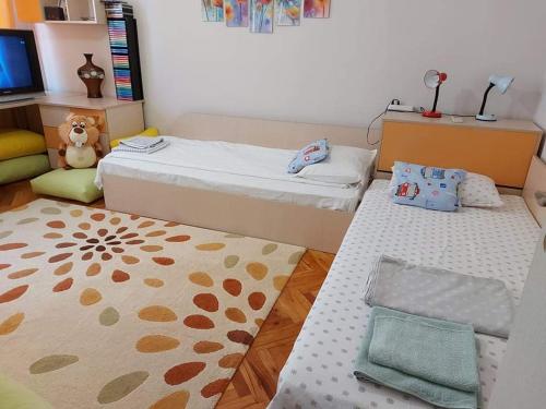布尔加斯Sweet Home的小房间设有两张床和地毯