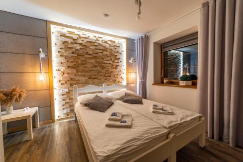 米科瓦伊基Promenada Apartamenty i Domek Nad Jeziorem的一间卧室设有一张床和砖墙