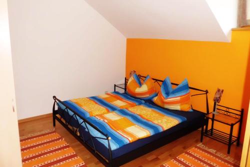 法克湖斯赫利特威瑟公寓的一间卧室配有一张带色彩缤纷的床单和枕头的床。