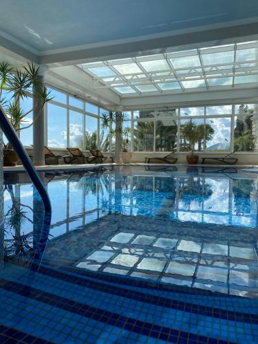 奥帕提亚萨沃伊酒店的大楼内一个蓝色瓷砖的大型游泳池
