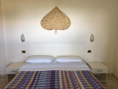 锡尔维玛丽娜埃琳娜俱乐部度假酒店的一间卧室配有一张带两张桌子和吊灯的床。