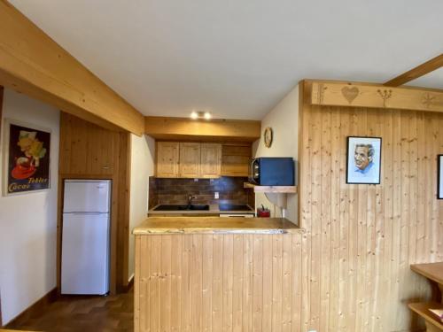 圣母贝莱克Le Courtis au Bourjaillet的厨房配有木制橱柜和白色冰箱。