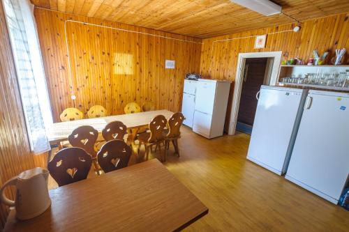 内林加Nostalgija Pervalkoje的厨房配有桌椅和冰箱。