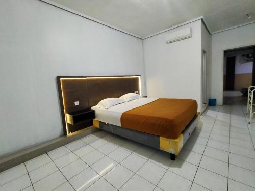 特尔纳特岛Hotel Nirwana Ternate RedPartner的一间卧室,卧室内配有一张大床