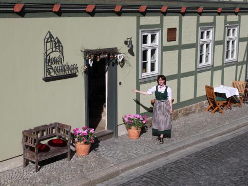 奎德林堡杜斯查兹酒店的站在建筑物前面的女人