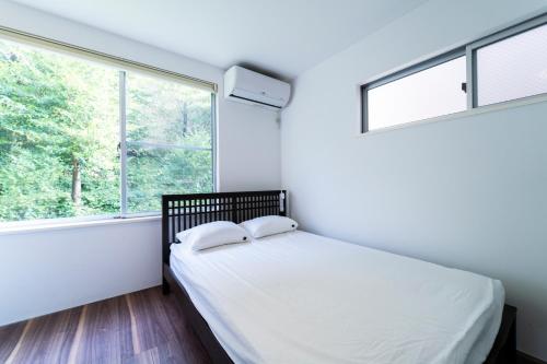 东京Shibuya-ku - House - Vacation STAY 11243的一间卧室设有一张床和两个窗户。