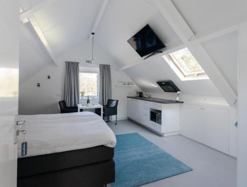 坎珀兰Slapen bij Jansz的白色卧室配有床、书桌和桌子