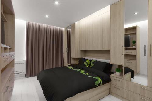 布尔加斯Perla Luxury Apartment的一间卧室配有一张黑色的床和一台电视。
