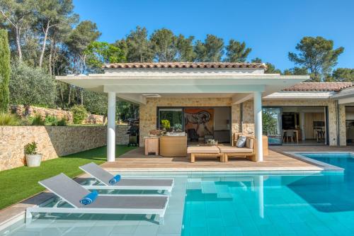 奥皮约la villa miel的一座房子旁的游泳池,配有两把躺椅