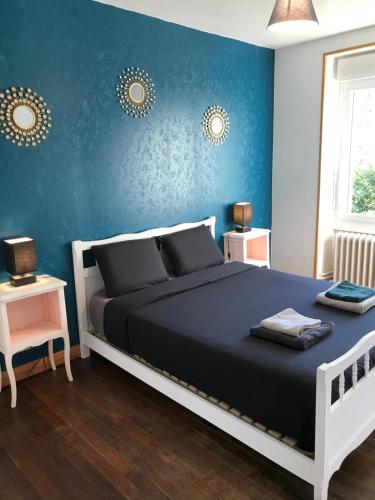 盖雷Appartement Guéret的一间卧室设有一张床和蓝色的墙壁