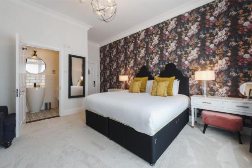 朴次茅斯萨默塞特豪斯精品餐厅酒店的一间卧室配有一张带花卉壁纸的大床