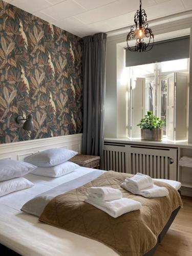 艾勒斯克宾Hotel På Torvet的一间卧室配有一张大床和毛巾