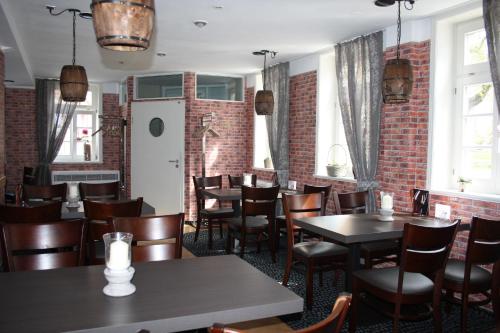 萨尔茨韦德尔Hotel & Restaurant Aragwi的一间带桌椅的餐厅以及砖墙
