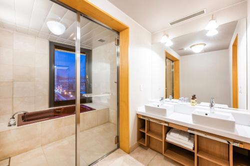 小樽Nord 小樽酒店的一间带两个盥洗盆和淋浴的浴室