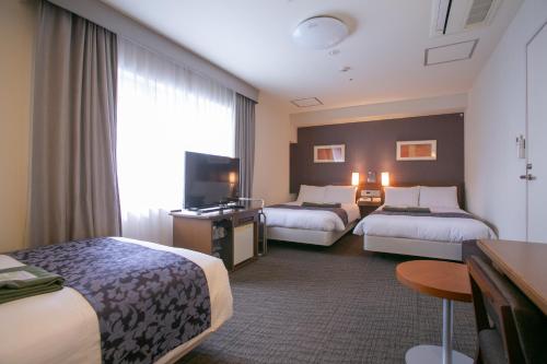大阪大阪花鱼俱乐部酒店的酒店客房设有两张床和电视。
