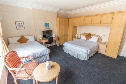 梅尔顿莫布雷The Quorn Lodge Hotel的酒店客房配有两张床和一张书桌