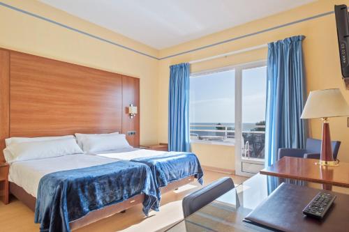 塔拉戈纳圣霍尔迪酒店的配有一张床、一张书桌和一扇窗户的酒店客房