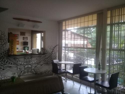 里约热内卢Hangar Rio Hostel的客厅配有桌椅和窗户。