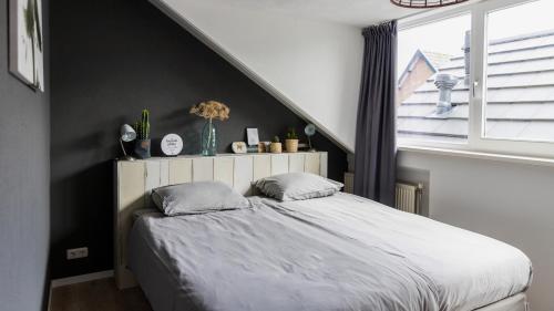 海边的艾格蒙特HuisjehurenEgmond的一间卧室设有一张床和一个窗口