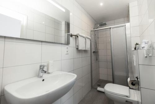 FischingenHotel & Restaurant Tanne的白色的浴室设有水槽和淋浴。