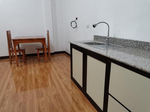 卡加盐德奥罗AFS Suites Barra, Opol的一间带水槽的厨房和木地板