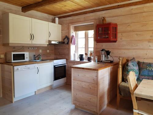 Bolstadøyri荣荣嘉德农家乐的一间厨房,配有白色家电和木墙