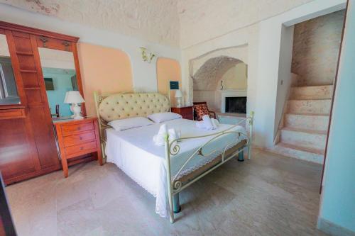 奥斯图尼Casal del Borgo的一间卧室配有一张床、一个梳妆台和壁炉